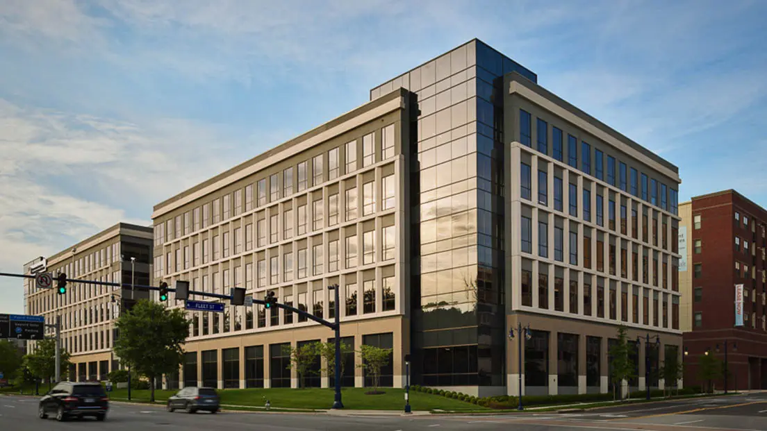 Modern multi-story commercial office building on an urban street corner.
