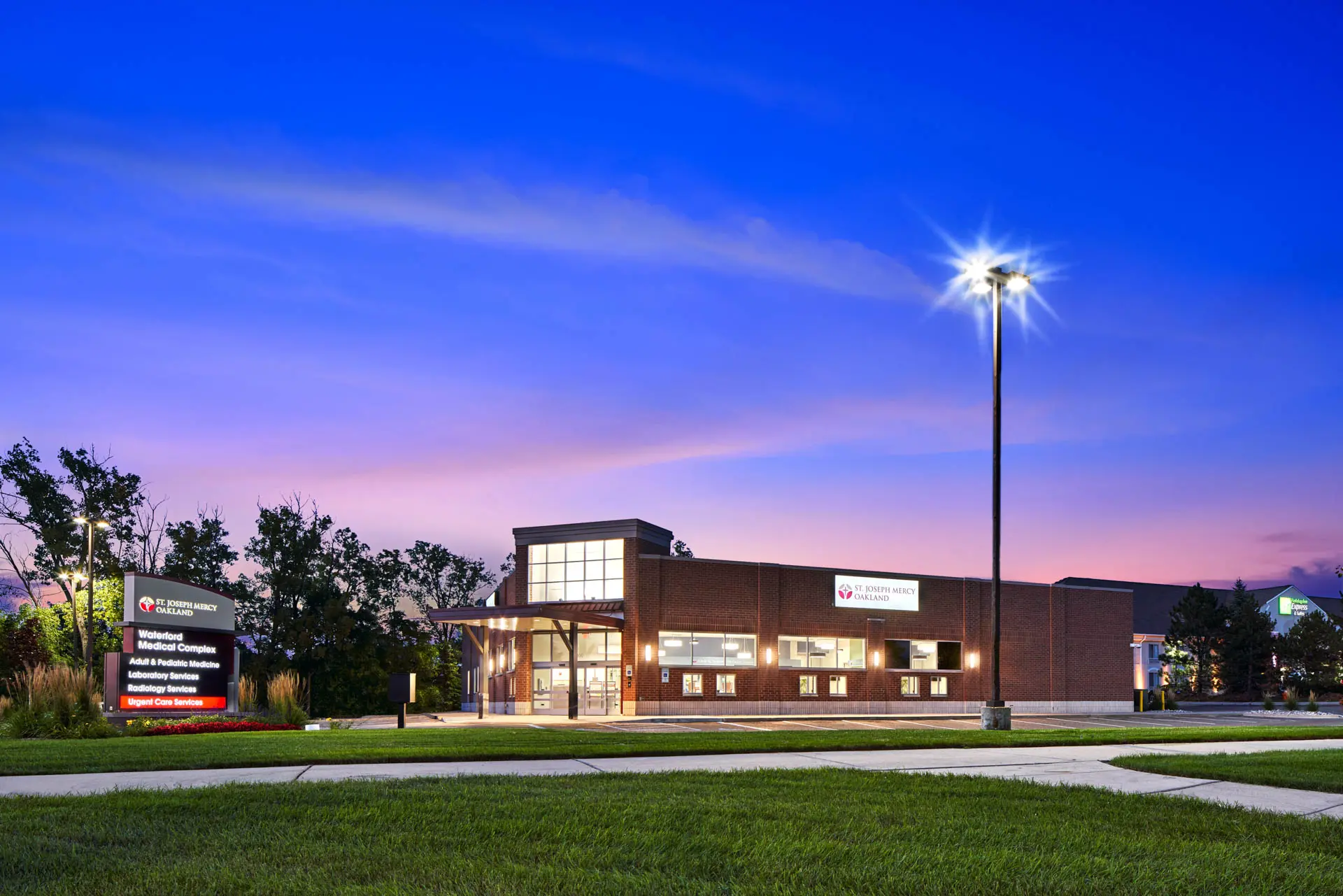 St. Joseph Mercy Oakland medical facility exterior illuminated at dusk.