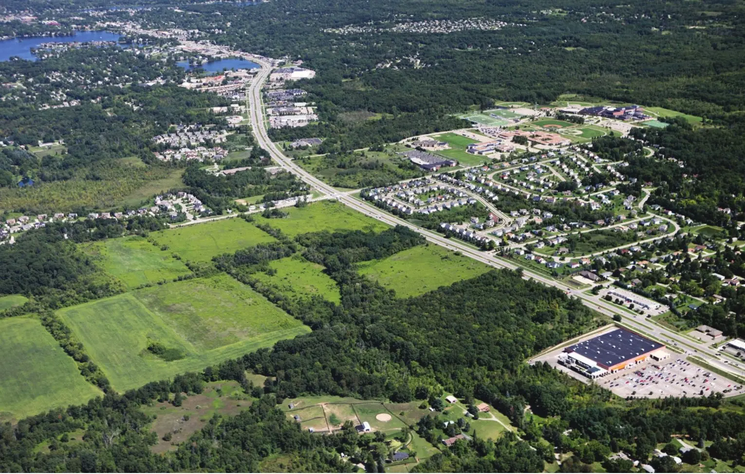 Aerial view of a development surrounded by roads and woodland
